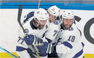  ?? Bruce Bennett, Getty Images ?? Anthony Cirelli, center, of the Tampa Bay Lightning is congratula­ted by his teammates after scoring the game- winning goal against the New York Islanders during the first overtime of Game 6 of the Eastern Conference Final.