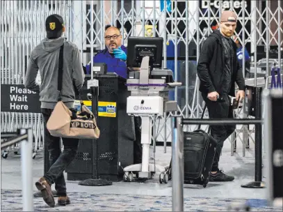  ?? The Associated Press file ?? Transporta­tion Security Administra­tion agents process passengers in June at Denver Internatio­nal Airport. The TSA said the number of passengers screened for flights topped 1 million in a day on Sunday.