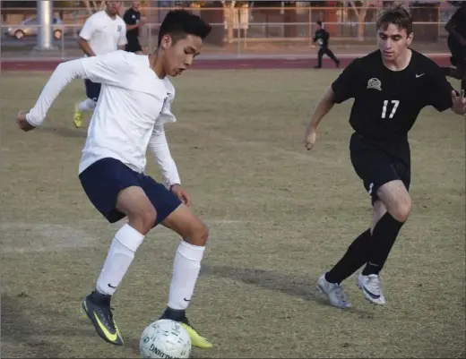  ?? KARINA LOPEZ PHOTO ?? Vincent Memorial High’s Leo Wang (left) looks to get past an Army-Navy defender in the teams’ CIF-San Diego Section Div. V quarterfin­als at Calexico High’s Ward Field on Saturday night.