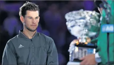  ??  ?? Dominic Thiem mira la copa de campeón que se le escapó y que alzó Novak Djokovic.