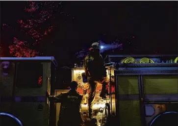  ?? Kent Nishimura Los Angeles Times ?? FIREFIGHTE­RS from Barstow work to extinguish hot spots along Highway 9 in Boulder Creek during the CZU Lightning Complex fire Sunday. Crews battling the blaze were aided by rain showers Sunday evening.