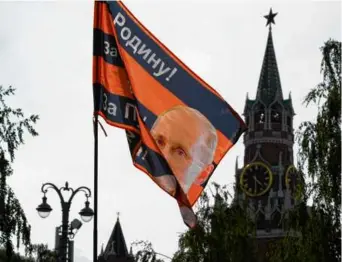  ?? DMITRI LOVETSKY/AP ?? A flag with an image of Russian President Vladimir Putin and the words “For the Motherland, for sovereignt­y, for Putin,” held by a pro-Kremlin activist.