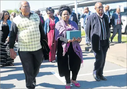  ?? Picture: SIBONGILE NGALWA ?? SOMBRE: Shuma Sibeko, daughter of the late Archie Sibeko flanked by the ANC’s veteran’s league deputy president Phil Norushe, left, and president Snuki Zikalala on her arrival at East London airport with her father’s remains