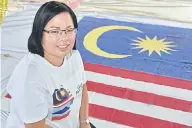  ??  ?? BANGGA: Hanna bangga dengan pasukannya yang bersemanga­t menyiapkan bendera.