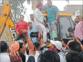  ?? HT PHOTO ?? Jalandhar (West) MLA Sushil Kumar Rinku (green shirt) mounts a bulldozer to stop the demolition of an illegal colony in Jalandhar on Friday.