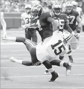  ?? Julian H. Gonzalez
Detroit Free Press ?? De’VEON SMITH of Michigan breaks a tackle by Brigham Young’s Michael Davis in the second quarter. Smith suffered an apparent ankle injury in the third.