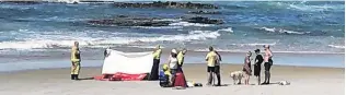  ?? PHOTO: SUPPLIED ?? Beach rescue . . . Emergency services and bystanders help one of the men who got into trouble at a beach near Brighton yesterday.