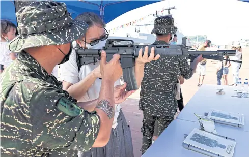  ?? ?? TENSE TIMES: Soldiers teach the public how to aim and shoot ahead of the national day celebratio­n in Kaohsiung, Taiwan yesterday.