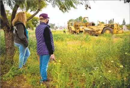  ?? JARROD VALLIERE U-T PHOTOS ?? Lakeside residents stand in protest Monday next to one of the jacaranda trees that are scheduled to be removed by Friday. San Diego County is removing the trees to make way for a new 16,400-square-foot library.