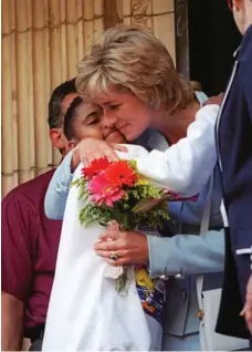  ?? PHOTO: BETH A. KEISER/AP ?? Diana, The Princess of Wales, gets a hug from Alexandria Zoriano, 11, of Chicago, as she leaves the Cook County Hospital in Chicago in 1996.