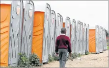  ?? Pictures: FREDLIN ADRIAAN ?? STOPGAP SOLUTION: A pupil walks past the temporary toilets at Zanoxolo Public Primary School yesterday