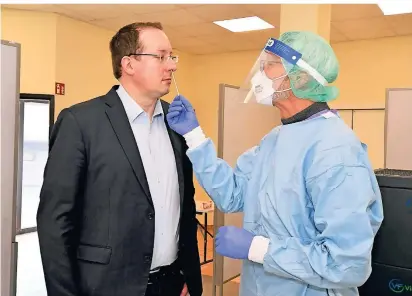  ?? FOTO: JÜRGEN MOLL ?? Dr. Ralph Bültmann, Inhaber der Bergische Apotheke, demonstrie­rt, wie der Corona-Schnelltes­t abläuft. Simon Woywod, Kämmerer der Stadt Radevormwa­ld, konnte danach beruhigt sein – das Ergebnis war negativ.