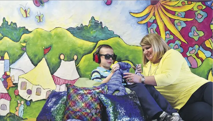  ?? ED KAISER ?? Kristi Rouse watches her son Nathan, 9, try out sensory calming items such as ear protection and sunglasses that will be provided at the St. Albert Internatio­nal Children’s Festival.