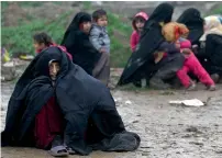  ?? — AFP ?? Civilians sit on the road as they escaped from the city of Mosul.