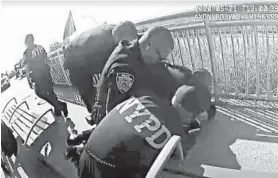  ?? NYPD ?? In a photo taken from video, New York police officers arrest a man Sunday on the Rockaway Beach boardwalk. One officer was suspended for using a chokehold in the arrest.
