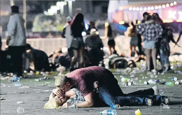  ?? DAVID BECKER / AFP ?? Un joven atiende a una mujer herida en el tiroteo, que se produjo durante el Route 91 Harvest Festival