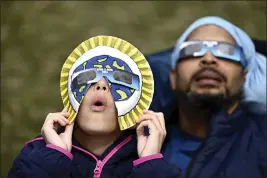  ?? JUSTIN TANG — THE CANADIAN PRESS VIA AP ?? Dezaray Butts and her father Douglas wear solar eclipse glasses Monday as they observe the partial phase of a total solar eclipse, in Kingston, Ontario.