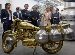  ?? — AFP ?? French President Emmanuel Macron and his wife Brigitte listen to artiste Subodh Gupta ( centre) during a visit to his showroom in Gurgaon late on Sunday.