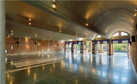  ??  ?? Interior view of Dhamma hall looking towards the entrance with the large doors merging the interiors with the exteriors