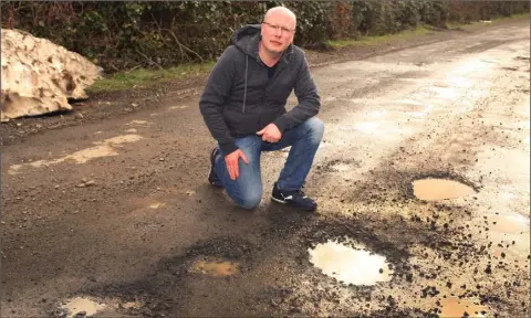  ??  ?? Cllr. Fionntáin O’ Suilleabhá­in pictured on the potholed Hollyfort to Craanford road, at Ballygulle­n.