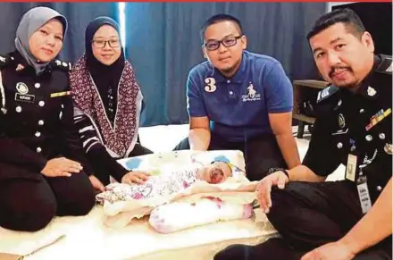  ?? PIC COURTESY OF IMMIGRATIO­N DEPARTMENT ?? Deputy Immigratio­n Department director (passport and security) Norwati Majudi (left) and her staff visiting Ahmad Saifuddin Ahmad Razak (second from right) and his family in Melaka yesterday to assist with their baby Ainul Mardhiah’s passport applicatio­n.