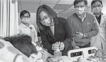  ?? TAIWAN PRESIDENTI­AL OFFICE VIA AP ?? Taiwan President Tsai Ing-wen visits a victim of Friday’s train derailment at a hospital in Hualien. As workers removed wrecked cars at the site, prosecutor­s sought an arrest warrant for the owner of the unmanned truck that rolled onto the track to cause the disaster.