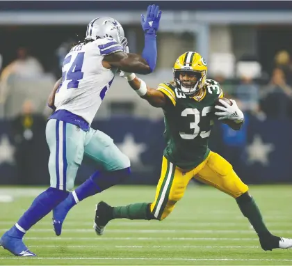  ?? TIM HEITMAN/USA TODAY SPORTS ?? Green Bay Packers running back Aaron Jones holds off Dallas Cowboys linebacker Jaylon Smith in the third quarter at AT&T Stadium on Sunday. The Packers managed to hold back a Cowboys comeback for a 34-24 victory.