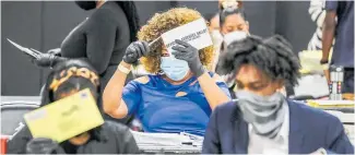  ?? Photo / AP ?? Election officials sort absentee ballots in Atlanta.