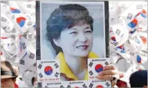  ??  ?? REUTERS A supporter of ousted South Korean leader Park Geun-hye holds up her portrait during a rally in front of a prosecutor’s office in Seoul on March 21, 2017.