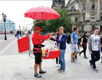  ?? RICK STEVES ?? Sampling one of Germany’s hundreds of sausage varieties from a portable human hotdog stand is a classic experience, but even restaurant­s in small German towns are starting to challenge culinary norms.