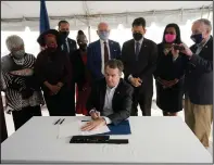  ?? (AP/Steve Helber) ?? Surrounded by legislator­s and activists Wednesday at Greensvill­e Correction­al Center in Jarratt, Va., Gov. Ralph Northam signs a bill abolishing the death penalty in Virginia.