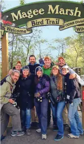  ??  ?? Kenn and Kimberly Kaufman (first row, left) pose with friends under the Magee Marsh Boardwalk sign.