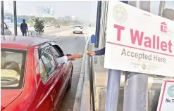  ?? — R. PAVAN ?? A motorist pays cash at a toll plaza on the Outer Ring Road, where the electronic toll management system has stopped working.