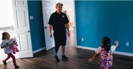  ?? Marie D. De Jesús / Houston Chronicle ?? Michael Villagran is all smiles as he gets a look at his new bedroom with daughters Alyssa, left, 5, and Carolina, 3.