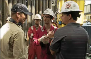  ?? LIONSGATE PUBLICITY ?? From left to right: Director Peter Berg (left), Jeremy Sande (“Adam Weise,” left center), Dylan O’Brein (“Caleb Holloway,” right center) and Mark Wahlberg (“Mike Williams,” right) behind the scenes in “Deepwater Horizon.”