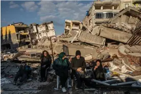  ?? Photograph: Alessio Mamo/The Observer ?? A displaced family in Samandağ sitting in front of the debris of their house after the earthquake.