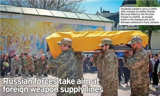  ?? ?? Ukrainian soldiers carry a coffin with remains of soldier Ruslan Borovyk killed by the Russian troops in a battle, as people kneel in the background, at St Michael cathedral in Kyiv, Ukraine