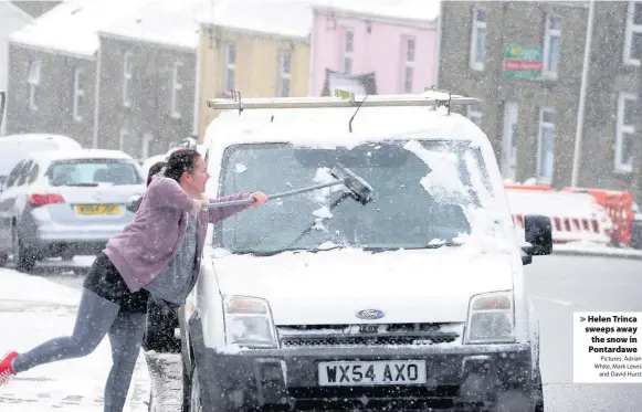  ?? Pictures: Adrian White, Mark Lewis and David Hurst ?? > Helen Trinca sweeps away the snow in Pontardawe