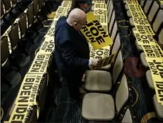  ?? Pete Marovich/The New York Times ?? A worker places campaign signs on seats March 12 in Washington before former Vice President Joe Biden spoke to the Internatio­nal Associatio­n of Firefighte­rs convention.