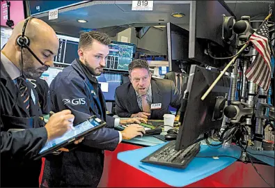  ?? Bloomberg News/MICHAEL NAGLE ?? Traders work Friday on the floor of the New York Stock Exchange, where investors’ worries over trade tensions led to another day of widespread losses.