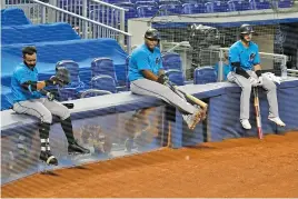  ?? AP PHOTO/LYNNE SLADKY ?? Miami Marlins’ Jonathan Villar, left, Jesus Aguilar, center, and Jon Berti wait to bat during a July 12 scrimmage at Marlins Park in Miami.