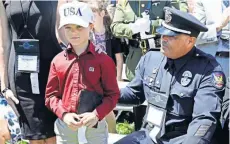  ??  ?? Un policía y su hijo en la ceremonia en honor a los policías muertos en acción, ayer en Washington DC.