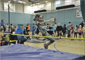  ??  ?? A youngster clears the bar in the high jump.