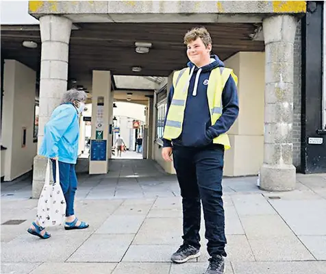  ??  ?? James Smalley is one of the new Covid marshals in Penzance, Cornwall, who help people to follow guidelines and respect social distancing, which will be stricter from Monday