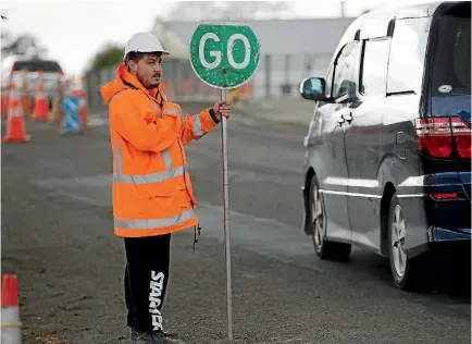  ?? PHOTO: MURRAY WILSON/STUFF ?? Kayne Wills works on the most visible part of the traffic management plan on Botanical Rd – the stop-go sign.