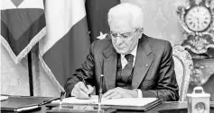  ??  ?? Mattarella signs the document for the dissolutio­n of the Houses of Parliament. — AFP photo