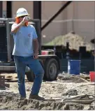  ?? RECORDER PHOTO BY CHIEKO HARA ?? A constructi­on worker takes a drink of water Tuesday at Portervill­e High School.