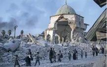  ?? FELIPE DANA/ASSOCIATED PRESS FILE PHOTO ?? LEFT: Fleeing Iraqi civilians walk past the heavily damaged alNuri mosque last week as Iraqi forces continue their advance against Islamic State militants in the Old City in Mosul, Iraq.