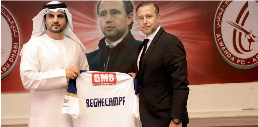  ?? — Supplied photo ?? Board member Dr Jamal Al Hosni presents the Wahda jersey to new coach Laurentiu Reghecampf.