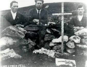  ??  ?? A humble wooden cross marks the spot where Liam Lynch fell. The gun (foreground) was understood to belong to the general. The three men in the picture are unidentifi­ed.